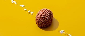 Man brain and pills around on yellow background