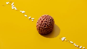 Man brain and pills around on yellow background