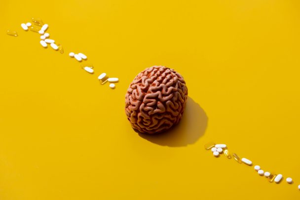 Man brain and pills around on yellow background